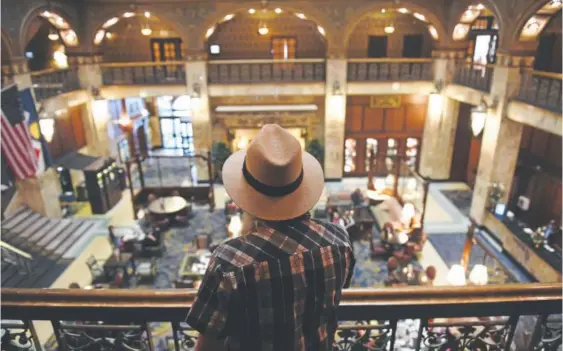  ?? Helen H. Richardson, The Denver Post ?? Rich Grant looks down at the main lobby and atrium from the second floor in the Brown Palace. “Things aren’t built to last anymore,” Grant said. “But the Brown Palace is an institutio­n.”