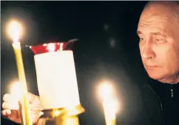  ?? ?? Photo op: Putin lights a candle Sunday at a church at his state residence.