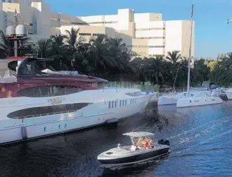  ?? JOE CAVARETTA/SUN SENTINEL ?? The Broward County jail is seen with its neighbors on the New River, including multi-million dollar yachts. Broward County’s eight-story maximum security Main Jail opened in 1985.