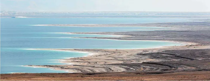  ?? FOTOS: DPA ?? Der Blick geht vom Kibbutz En Gedi direkt auf das zurückgehe­nde Ufer des Toten Meeres, wo der Wasserspie­gel derzeit um mehr als einen Meter pro Jahr sinkt.