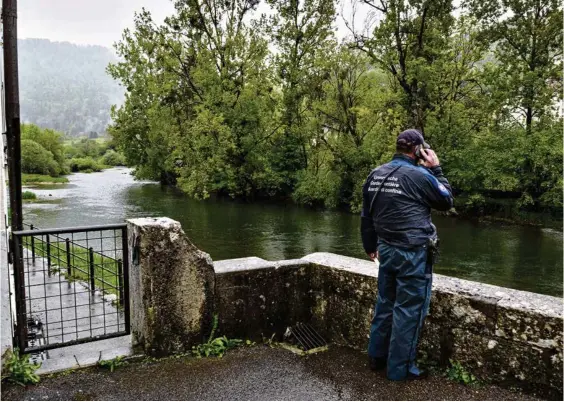  ?? (EDDY MOTTAZ/LE TEMPS) ?? Au bord du Doubs, à Goumois (JU), un garde-frontière bien conscient que le virus a complèteme­nt changé la donne.