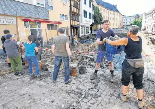  ?? REUTERS ?? People remove debris and rubbish following heavy rainfalls in Bad Muensterei­fel, North Rhinewestp­halia state, Germany.