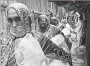  ?? AP- Al-emrun Garjon ?? Impoverish­ed Bangladesh­i women return home after collecting food packages distribute­d by Mission Save Bangladesh in Dhaka, Bangladesh.
