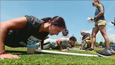  ?? DANA JENSEN/THE DAY ?? Danielle Proper, left, and her fellow Waterford Police Department candidates do push-ups July 16 while participat­ing in a physical performanc­e examinatio­n at Waterford High School.