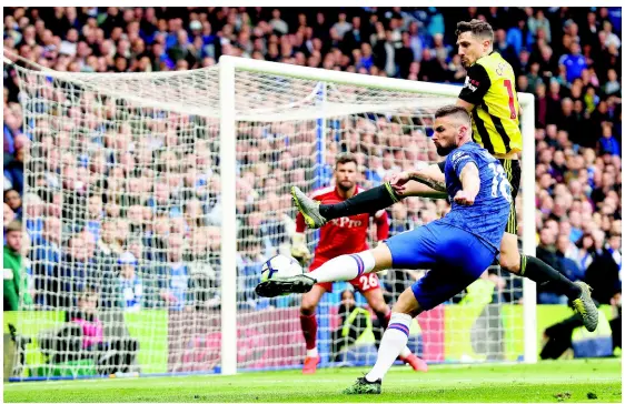  ?? AP ?? Chelsea’s Olivier Giroud (front) connects with the ball to hit a powerful shot past Watford’s Craig Cathcart (top) during their English Premier League match at Stamford Bridge in London yesterday.