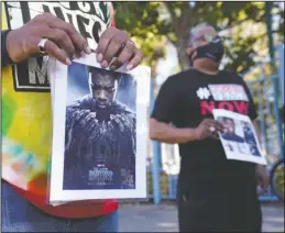  ?? The Associated Press ?? LOSS: A portrait of the late actor Chadwick Boseman as the character T'Challa in the 2018 film "Black Panther" is held by a participan­t in a news conference celebratin­g his life, Aug. 29, in Los Angeles. Boseman died Friday at 43 after a four-year fight with colon cancer.