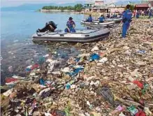  ??  ?? ANGGOTA polis Indonesia turut menyertai kempen membersihk­an sampah dari Teluk Lampung di perkampung­an Sukaraja dekat Bandar Lampung. - AFP
