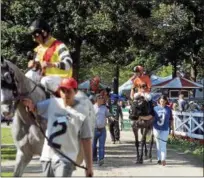  ?? DAVID M. JOHNSON — DJOHNSON@DIGITALFIR­STMEDIA.COM ?? Horses are led from the paddock to the main track for the post parade before the start of Race 7on Monday at Saratoga Race Course.