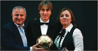  ?? – AFP ?? DREAM COME TRUE: Real Madrid’s Croatian midfielder Luka Modric (C) pose with his parents after the 2018 Ballon d’Or award ceremony at the Grand Palais in Paris.