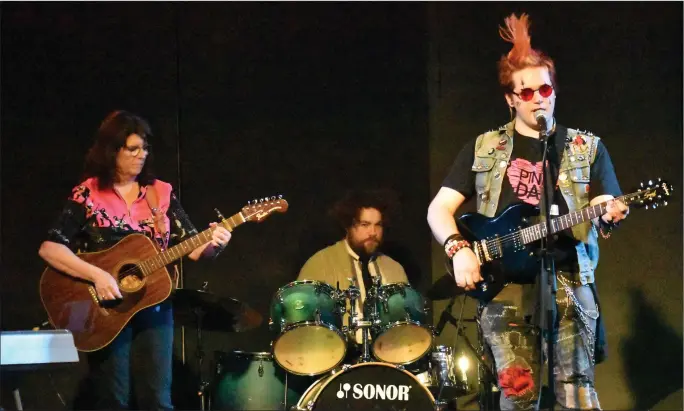  ?? Photo by Matthew Liebenberg/Prairie Post ?? Hunter Flaterud performs a song with music teachers Glenna Switzer on guitar and Stacy Tinant on drums.