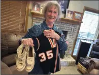  ?? (AP/Eric Olson) ?? Nancy Schmitz poses at her home in La Vista, Neb., with the jersey and sneakers she wore when she played 6-on-6 basketball at Elk Horn-Kimballton High School in the 1960s. Schmitz, then Nancy Wolken, was a third-team all-state pick in 1968.