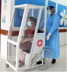  ??  ?? A patient being transporte­d in novel infectious patient transporta­tion chamber