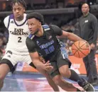  ?? JOE RONDONE/THE COMMERCIAL APPEAL ?? Memphis guard Alex Lomax drives past East Carolina’s Tristen Newton on Jan. 27 at Fedexforum.