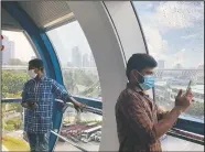  ??  ?? Migrant worker Natarajan Pandiaraja­n (right) enjoys the view on board the Singapore Flyer.