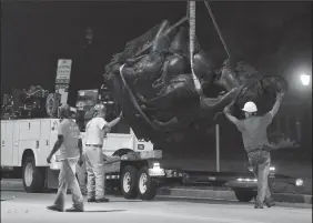  ?? JERRY JACKSON/BALTIMORE SUN ?? Workers remove a monument dedicated to the Confederat­e Women of Maryland near the intersecti­on of Charles St. and University Parkway early Wednesday morning.