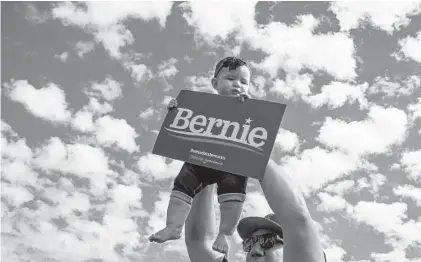  ?? ALLEN J. SCHABEN/LOS ANGELES TIMES ?? David Reyes holds up his baby, 8-month-old Galadriel Reyes, at a rally for Bernie Sanders in Santa Ana, California, on Feb. 21.