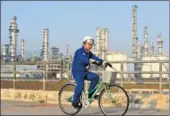  ?? XINHUA ?? A bicycle-riding security supervisor patrols the industrial park of CNOOC and Shell Petrochemi­cals Co Ltd, which is one of the largest petrochemi­cal joint ventures in China.