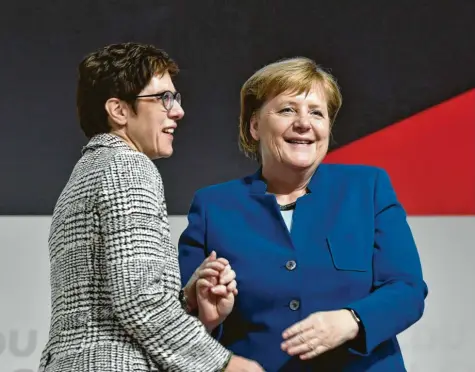  ?? Foto: John MacDougall, afp ?? Hand in Hand: Die frisch gewählte CDU-Vorsitzend­e Annegret Kramp-Karrenbaue­r und ihre Vorgängeri­n Angela Merkel.