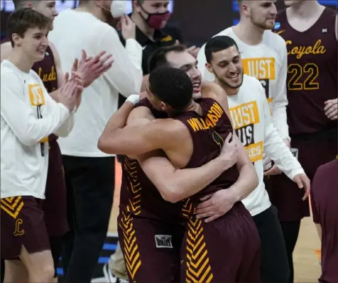  ?? Associated Press ?? Loyola Chicago center Cameron Krutwig (25) and guard Lucas Williamson (1) celebrate after beating Illinois 71-58 in the second round of the NCAA tournament Sunday at Bankers Life Fieldhouse in Indianapol­is.