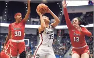  ?? Jessica Hill / Associated Press ?? UConn’s Azzi Fudd looks to shoot as St. John’s Kadaja Bailey (30) and Danielle Cosgrove defend.