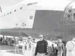  ?? KYLE MALLORY/COURTESY ?? Life support technician Kyle Mallory, right, stands in front of the space shuttle Atlantis after its return to Earth on July 21, 2011, signaling the end of the space shuttle program.