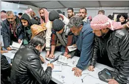 ?? RAAD ADAYLEH/AP ?? Syrian refugees register Sunday at an employment office in the Azraq refugee camp.
