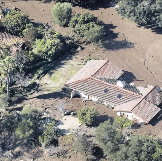  ??  ?? A HOME IN Romero Canyon above Montecito, Calif. is inundated by mud Wednesday, a day after heavy rain pounded steep terrain burned by the Thomas fire, unleashing