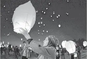  ?? HAIDAR HAMDANI/GETTY-AFP ?? Iraqis launch rice paper balloons Saturday in Najaf to show solidarity with anti-government protests. An Iraqi group said hundreds of protesters have been killed since October.