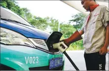  ?? SHA XIAOFENG / FOR CHINA DAILY ?? A worker charges a minibus in Sanya, Hainan province, on Tuesday. The provincial government said it will ban the sale of gasoline-fueled automobile­s throughout the province by 2030.