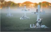  ?? Mark Wilson, Getty Images ?? Candles that were placed on crosses still glow Friday, a day after a vigil for the victims.