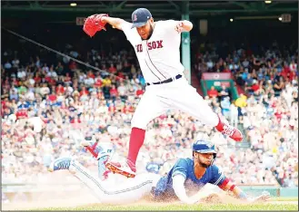  ??  ?? Boston Red Sox starting pitcher Eduardo Rodriguez leaps to try to avoid a sliding Toronto Blue Jays’ Lourdes Gurriel Jr on a play at first base during the sixth inning of a baseball game on July 14, in Boston. (AP)