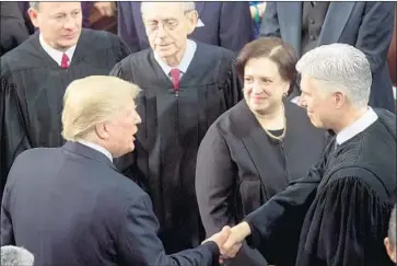  ?? Saul Loeb AFP/Getty Images ?? PRESIDENT TRUMP greets Supreme Court justices including Neil M. Gorsuch, right. Administra­tion lawyers want justices to rule quickly on the fate of “Dreamers” and an abortion dispute involving young migrants.