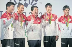  ?? REUTERS ?? Prime Minister Shinzo Abe poses with Japan’s 4x100m silver medallists.