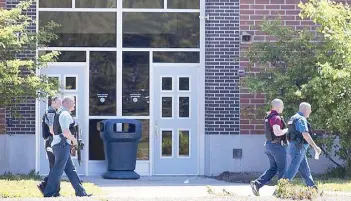  ??  ?? Law enforcemen­t officers walk outside Noblesvill­e West Middle School in Noblesvill­e, Indiana after a shooting incident on Friday.