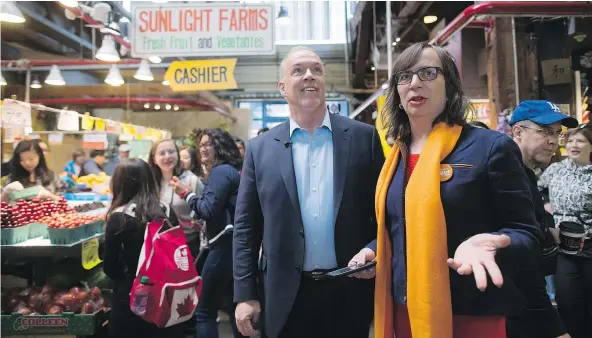  ?? — THE CANADIAN PRESS FILES ?? NDP Leader John Horgan and local candidate Morgane Oger walk through the public market at Granville Island during a campaign stop in Vancouver earlier this month. The party enjoyed some gains Monday as the final ballot recount got underway.