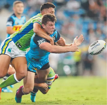  ?? Picture: GETTY IMAGES ?? Jai Arrow gets the ball away despite being swamped by the Canberra defence during the Titans’ Round 1 clash.