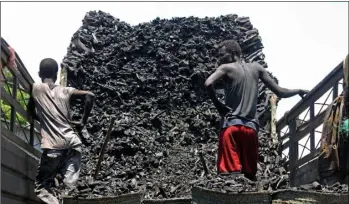 ?? AP PHOTO/FARAH ABDI WARSAMEH ?? In this 2012 file photo, Somali porters offload charcoal from a truck at a charcoal market in Mogadishu, Somali.