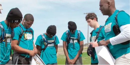  ?? ADRIAN SAINZ/ AP ?? A group of teenagers from Mississipp­i and their mentor, Jarvis Ward, right, say a prayer before launching a 50- mile march to Memphis as a tribute to slain civil rights leader Dr. Martin Luther King Jr. on Saturday in Dundee, Miss.