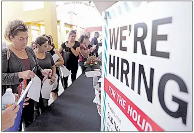  ?? AP ?? People wait to apply for seasonal employment at a job fair in Sweetwater, Fla., in October. Payroll processor ADP reported December job gains reflected hiring in health care, profession­al services and retail.