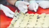  ?? XINHUA PHOTOS ?? Experts seek to put emphasis on the background stories in the restoratio­n of ancient Chinese art and calligraph­y at this year’s internatio­nal forum on art preservati­on in Beijing.