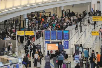  ?? Angela Weiss / AFP via Getty Images ?? Passengers enter security checkpoint­s at John F. Kennedy Internatio­nal Airport on May 28. The airline industry is facing a surge in cases of unruly passengers and sometimes violent behavior.