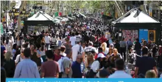  ?? — AFP ?? BARCELONA: Tourists walk up and down Las Ramblas alley in Barcelona.