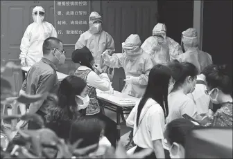  ?? XIA SHIYAN / FOR CHINA DAILY ?? People wait to get nucleic acid tests for COVID-19 at an office building in Guangzhou, Guangdong province, on Sunday. The tests were offered free for people who had visited a nearby shopping mall where a case of coronaviru­s emerged recently.