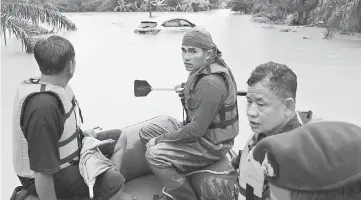  ??  ?? File photo shows rescue workers ride a boat as they patrol an area flooded in Sichon District, Nakhon Si Thammarat province, Thailand. — Reuters photo