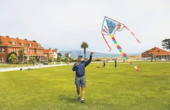  ?? Photos by Gabrielle Lurie / The Chronicle ?? Rahul Young throws a kite into the sky at the Main Parade Grounds in the Presidio in S.F.