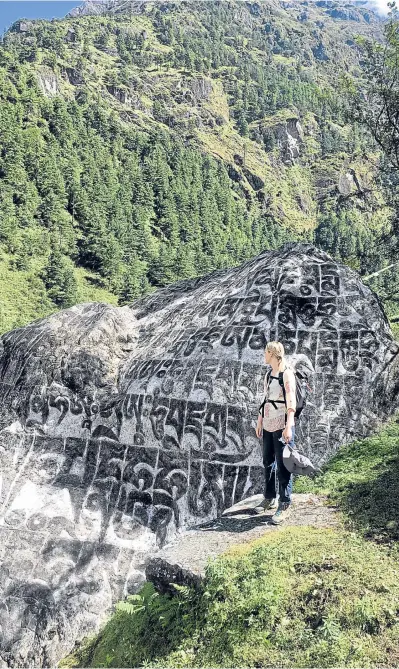  ??  ?? A boulder with Tibetan prayers