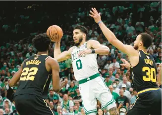  ?? GETTY ?? The Celtics’ Jayson Tatum passes around pressure from the Warriors’ Stephen Curry and Andrew Wiggins in the fourth quarter of Game 4 of the NBA Finals on Friday at TD Garden in Boston.