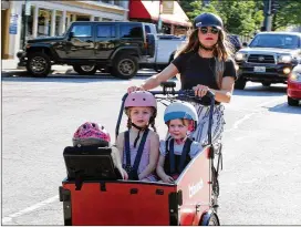  ?? COURTESY OF BUNCH BIKES ?? Bunch Bikes’ Original electronic cargo bike holds up to four kids, seated and secure with three-point seat belts and a rear rack that holds up to 66 pounds.