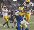  ?? The Canadian Press ?? Edmonton Eskimos’ C.J. Gable leaps over Winnipeg Blue Bombers’ Taylor Loffler for the winning touchdown during second-half CFL playoff action in Winnipeg on Sunday. The Eskimos won the West semifinal 39-32.