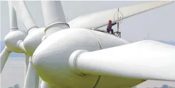  ?? FOTO: DPA ?? Ein Techniker justiert ein Windmessge­rät auf einem Enercon-Windkraftr­ad: Baden-Württember­gs Umweltmini­ster Franz Unterstell­er kritisiert, dass Bürgerener­giegenosse­nschaften unbotmäßig bevorzugt werden.
